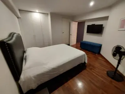a bedroom with a white bed and a blue chair at MLA apartments - Bolognesi in Lima