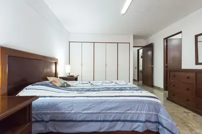a bedroom with a large bed with a wooden headboard at Apartamento Edificio Pardo Cinco in Lima