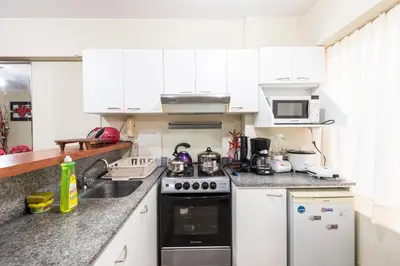 a kitchen with white cabinets and a stove top oven at Apartamento Edificio Pardo Cinco in Lima