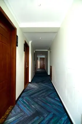 an empty hallway with a blue rug on the floor at Lyz Business Hotel in Lima