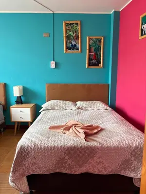 a bedroom with a bed with pink and blue walls at La Casa de Bamboo in Ica