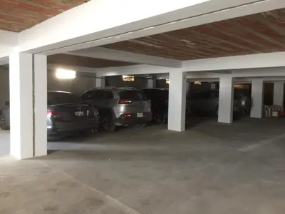 a parking lot with cars parked in a garage at Hotel Balistra in Ica