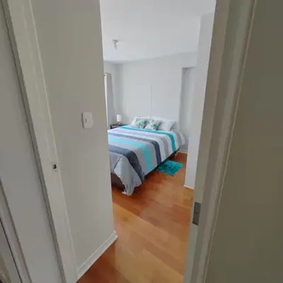 a bedroom with a bed in a white room at Elite Apartment 2 in Cusco