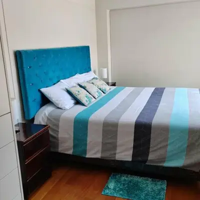 a bedroom with a bed with a blue headboard at Elite Apartment 2 in Cusco
