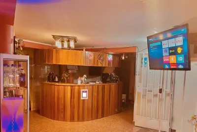 a kitchen with a bar and a large screen at Hostal El Rancho in Huancayo