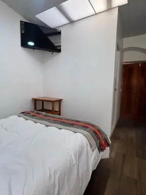 a bedroom with a bed and a tv on the ceiling at Hospedaje Killipata in Cusco