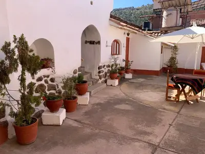 a patio with potted plants and a table and an umbrella at Hospedaje Killipata in Cusco