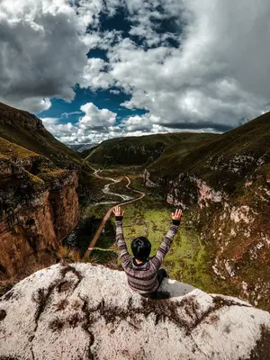 a person sitting on a rock with their hands in the air at Hostal Berlin in Jauja