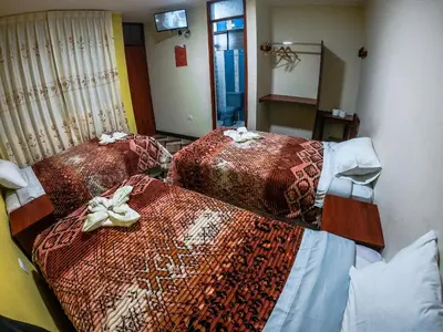 a room with three beds with scarves on them at Hostal Berlin in Jauja