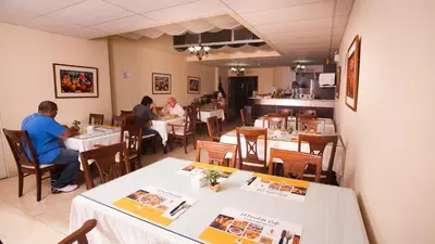 a dining room with people sitting at tables in a restaurant at Hotel El Farolito in Lima