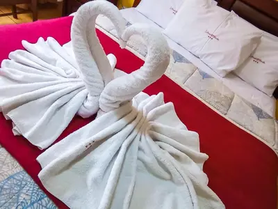 two white towel swans sitting on a red table at Hotel El Farolito in Lima