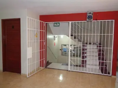a room with a door and a cell with a gate at Antares Inn in Lima