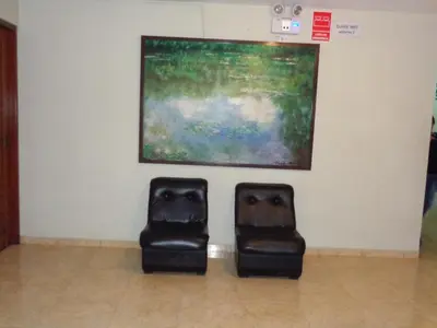 two black chairs sitting next to a painting at Antares Inn in Lima
