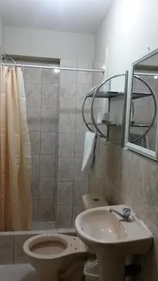 a bathroom with a toilet and a sink and a shower at Antares Inn in Lima