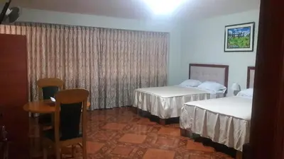 a hotel room with two beds and a table at Antares Inn in Lima