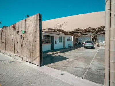 a large building with a car parked in a parking lot at Ecocamp Huacachina in Ica