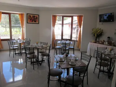 a dining room with tables and chairs and windows at Cusco House in Cusco