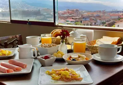 a table with breakfast foods and drinks on it at Tikala Cusco Boutique Hotel in Cusco