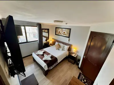 a bedroom with a bed and a large window at Tikala Cusco Boutique Hotel in Cusco