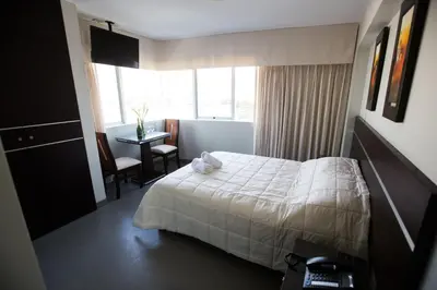 a hotel room with a bed and a desk and a window at Mariategui Hotel & Suites in Lima