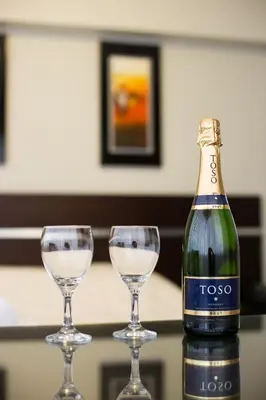 two wine glasses sitting next to a bottle oftococo at Mariategui Hotel & Suites in Lima