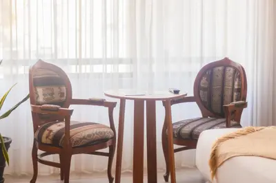 a room with two chairs and a table and a window at Naia Hoteles in Lima