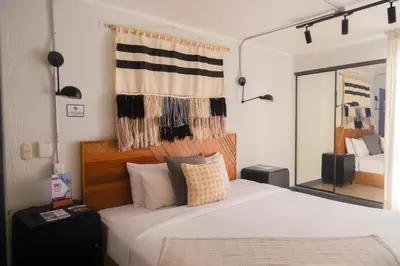 a bedroom with a large white bed with a mirror at Naia Hoteles in Lima