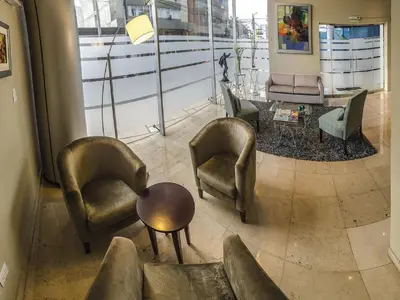 a living room with chairs and a table and a couch at Del Pilar Miraflores Hotel in Lima