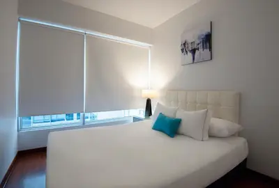 a bedroom with a white bed with a large window at Mariel Hotel Boutique in Lima