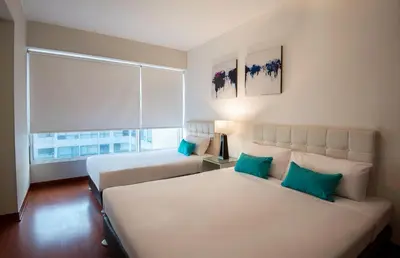 a bedroom with two beds and a large window at Mariel Hotel Boutique in Lima