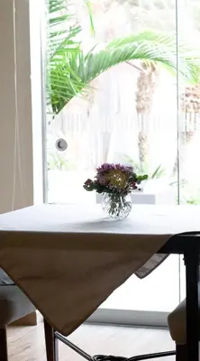 a vase of flowers sitting on a table next to a window at El Golf Hotel Boutique in Lima
