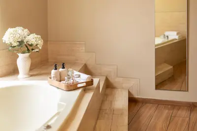 a bathroom with a tub and a vase with flowers at Hotel Park Suites in Lima