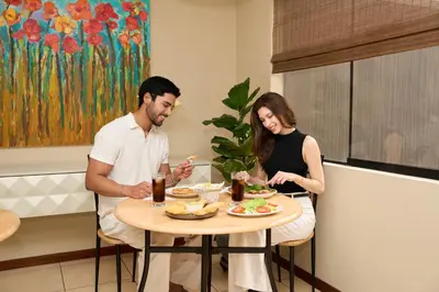 a man and woman sitting at a table eating food at Hotel Park Suites in Lima