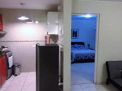a room with a kitchen and a bedroom with a bed at Host, Apartment for rent in Lima