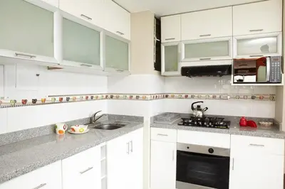 a white kitchen with white cabinets and a sink at Host, Apartment for rent in Lima