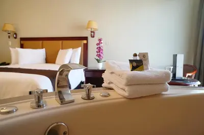 a bathroom with a sink and a bedroom with a bed at Gran Mundo Hotel & Suites in Lima
