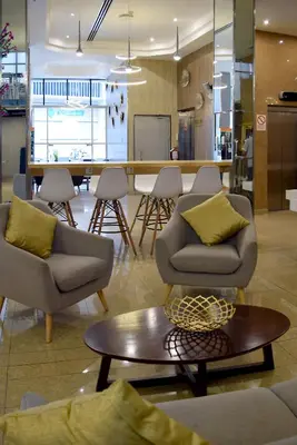 a living room with couches and a table and a kitchen at Gran Mundo Hotel & Suites in Lima
