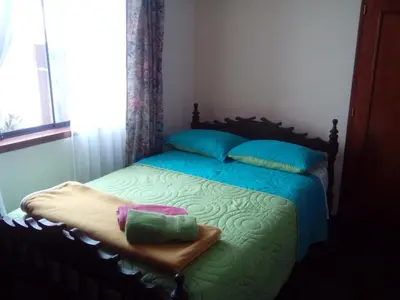 a bedroom with a bed with blue and green sheets at Hospedaje La Anita in Lima