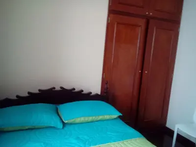 a bedroom with a bed with a wooden headboard at Hospedaje La Anita in Lima