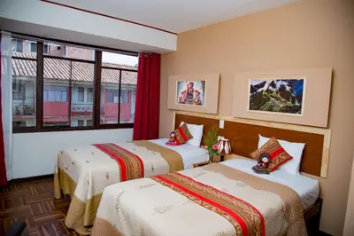 a hotel room with two beds and a window at Euler House`s in Cusco