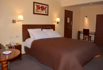 a hotel room with a large bed and a table at Illariy Hotel in Huancavelica