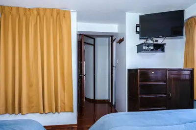 a hotel room with a bed and a television at Casa de Laura in Cusco