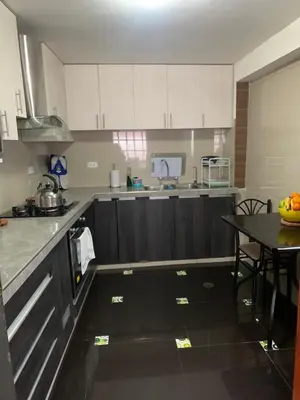 a kitchen with white cabinets and a table in it at Casa de Laura in Cusco