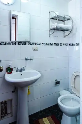 a white bathroom with a sink and a toilet at Casa de Laura in Cusco