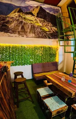 a room with a couch and a painting on the wall at Ukumari Hostel in Cusco