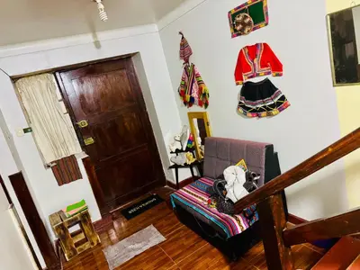 a living room with a couch and a wooden floor at Ukumari Hostel in Cusco