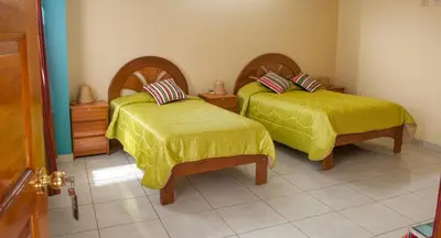 a room with two beds with yellow covers at B&B Valcava in Urubamba