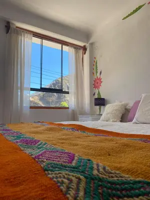 a bedroom with a bed with a large window at Hostal Chaska Wasi in Ollantaytambo