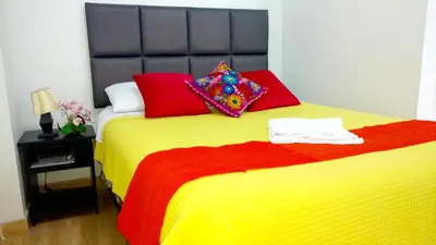 a bedroom with a large bed with colorful pillows at Hostal Mica in Abancay
