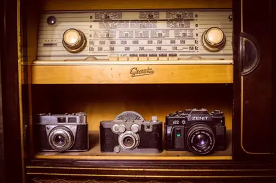 three cameras sitting on a shelf with a radio at Hostal Mica in Abancay